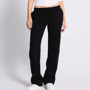 Svarta mjukisbyxor med snörning - Svarta mjukisbyxor med rak passform och snörning i midjan. Byxorna har en avslappnad look och är tillverkade i mjukt material som passar perfekt för chill dagar. Klassisk design utan synliga loggor eller mönster.