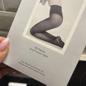 Svarta tunna tights från Swedish Stockings - Säljer 5 par dark green, semi-transparenta tights från Swedish Stockings, modell Svea Premium Tights med 30 denier. De har bekväm midja, förstärkta tår och är tillverkade av 89% återvunnen polyamid och 11% elastan. Perfekta för att ge en snygg och stilren look.