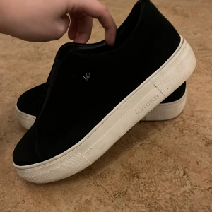 K.cobler skor  - Svarta sneakers med tjock vit platt sula.  Ovandelen är i mocka och har en stilren look utan synlig snörning. Använda 1 gång för att dom va för små för mig. Dom är som nya och köpta för 1.300