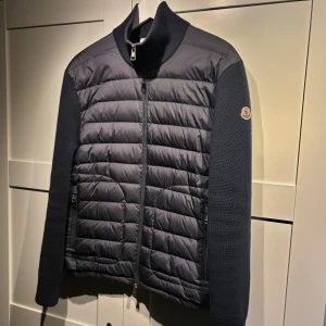 Moncler Cardigan - Stilren Cardigan från Moncler! Färgen är Navy och är i storlek Medium. Nypris ligger på 9999 kr. Knappt använd alls, säljer då jag är sugen på nytt! Skriv för frågor! 