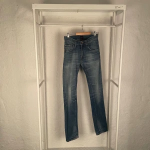 Tiger of sweden Iggy 30/32 - Snygga blå jeans från Tiger of Sweden med klassisk femficksdesign och bruna detaljer på bakfickan. Jeansen har raka ben och normal passform, tillverkade i slitstarkt bomullsjeans. Perfekta för dig som gillar stilrena och tidlösa jeans.