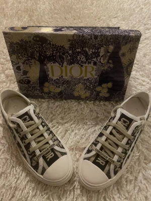 Dior sneakers - (storlek 39 passar även 38) - Säljer ett par Dior sneakers i storlek 39. Skorna är endast provade inomhus då de tyvärr var för stora för mig. De är alltså i nyskick. Modellen är en normal 39 men upplevs något liten, skulle även kunna passa dig som har 38. Väldigt snygga och stilrena, lätta att matcha till olika outfits. Originalkartong medföljer.  Info:     •    Dior sneakers     •    Storlek 39 (passar även 38)     •    Endast provade     •    Nyskick     •    Svart/vit med Dior-mönster     •    Originalkartong