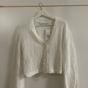 Vit stickad kofta från Kappahl - Säljer en vit stickad kofta från Kappahl i storlek S. Koftan har ett fint mönster och knappar framtill. Jätte fin till ett vitt linne under. Aldrig använd då den inte riktigt är min stol