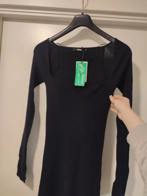 Svart stickad klänning Storlek M - En svart Stickad klänning från BikBok. Storlek M. Helt ny med prislapp. Liknade Adoore. Ord.pris 599kr.