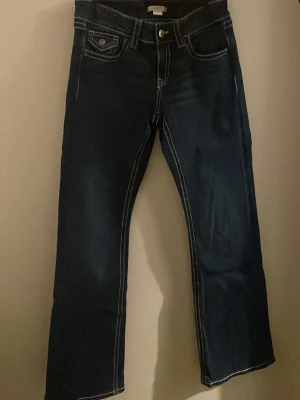 Mörkblå bootcut jeans - Säljer ett par mörkblå jeans med midwaist. Storlek 164! Säljer då de inte används längre!
