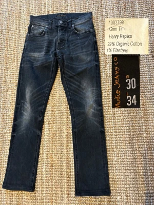 Nudie Jeans Grim Tim - Beskrivning:  Säljer mina Grim Tim från Nudie Jeans, storlek 30/34, men de sitter mer som 29/32. Klassisk slim-straight passform  Här är måtten 👇 Innerbenslängd: 72 cm  Totallämgd: 97 cm Midja 37 cm Benslut: 17 cm  De har riktigt fina fades och slitningar!  Hör av dig om du vill ha fler bilder! Pris ej hugget i sten!  Kolla min profil för mer liknande plagg 😊
