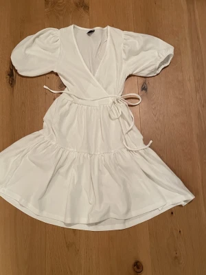 Vit kort klänning  - Vit kortare klänning med snöre i midjan och puffärm från Gina tricot. Mycket bra skick. Skriv om ni har frågor 🩷