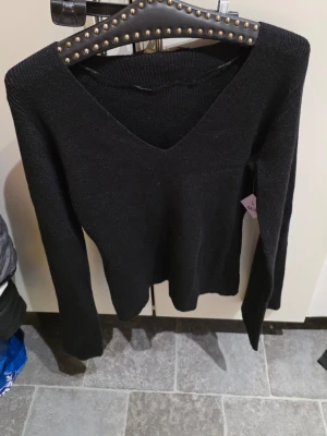 Svart stickad tröja Pernilla Wahlgren - Snygg svart stickad tröja från Pernilla Wahlgren med djup V-ringning och långa ärmar. Tröjan har en enkel och stilren design som passar till det mesta. Mjuk och skön kvalitet, perfekt för kyligare dagar.