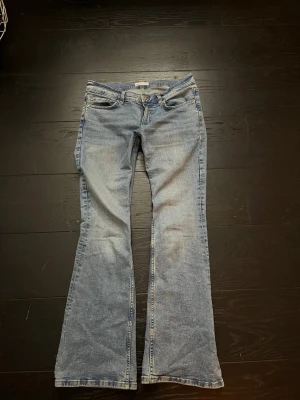 Ljusblå bootcut jeans - Säljer ett par ljusblå bootcut jeans med klassisk femficksdesign och låg midja. Jeansen har en lätt tvättad look och är tillverkade i denim med lite stretch för skön passform. Pris kan diskuteras!🥰