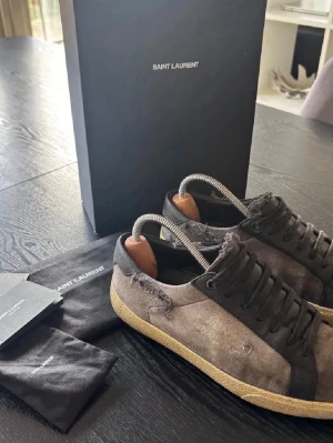 Saint Laurent skor - Storlek 39, passar 40. Lite grå/svart färg. Inga defekter. Allt og medkommer utom snören. Retail 9000kr. Där är tuggummi fast på skon på en sida fram och under skol och lågan på skon är solblekt så svårt läst men det ska va en söndrig modell så det är designen lite på dem så jag själv tycker dem är riktigt feta. Ingen retur!