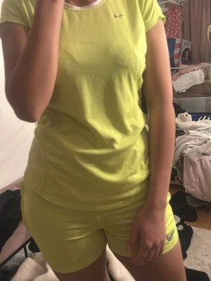 Gula träningsshorts från Nike - Snygga gula träningsshorts från Nike med klassisk logga på benet. Shortsen har en tight passform och är perfekta för dig som vill ha något bekvämt och sportigt. Materialet känns mjukt och stretchigt, vilket gör dem sköna att röra sig i.