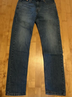 Levi's 502 - Klassiska blå jeans från Levi's med rak passform och fem fickor. Jeansen har en snygg tvättad look och är tillverkade i slitstark denim. Perfekta för en avslappnad och tidlös stil. Storlek 30/32, skriv för frågor.