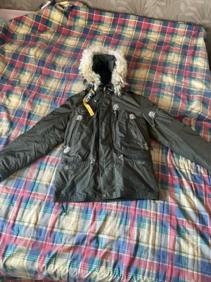 Mörkgrön parajumpers med päls - Skön parajumpers vinterjacka med luva, den har flera fickor och man kan byta till vårjacka om man tar bort det inre lagret så blir den tunnare typ som en windbreaker.