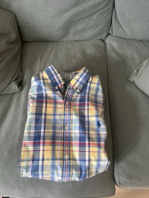 Rutig skjorta från Polo Ralph Lauren - Klassisk rutig skjorta från Polo Ralph Lauren i blå, gul, vit och röd. Aldrig använd och är helt skadefri