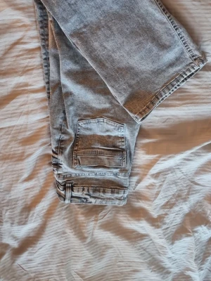 Grå jens bootcut low waist  - Säljer ett par grå jeans som är low waist och är bootcut. Jeansen är basic och har två fickor där bak små fickor där fram. 