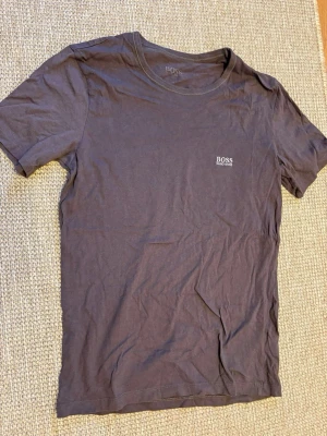 2 stycken Svarta BOSS t-shirts i bomull, M - Två stilrena svarta t-shirts från Hugo Boss i mjuk bomull. Klassisk passform med rund hals och diskret BOSS-logga på bröstet. Perfekta för en clean och enkel look, funkar till allt och är superbekväma.