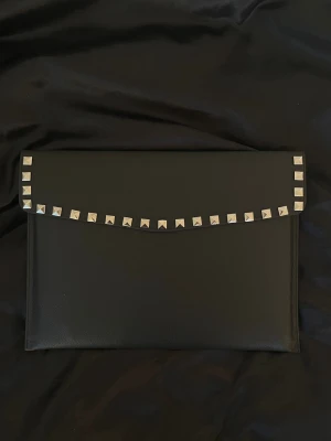 Dator fodral med silver nitar i läderimitation  - Rea – endast 199 kr (ord. pris 249 kr)! Stilrent datorfodral tillverkat av veganskt läder i vattentätt material. Fodralet skyddar din dator effektivt samtidigt som det ger din outfit en extra touch. 😇🩶 Storlek: 34 × 25 cm – passar svarta HP Chromebooks och andra datorer i liknande storlek. 