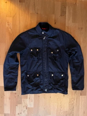 Vintage Peak Performance Field Jacket - En mörkblå peak performance jacka i super fint skick! Den har super fina details som dragkedja vid handlederna, P graverat på dragkedjan, manchester på insidan av kragen och 4 funktionella fickor. Pris kan definitivt diskuteras vid snabb affär och om ni har frågor så är det bara att skriva!