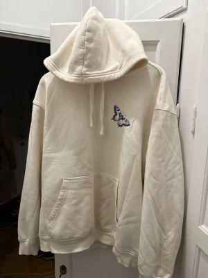 Relaxed Huvtröja Losse fit från H&M - Vit huvtröja med logga på fram sidan och text på ryggen. Perfekt nu vid vintern!