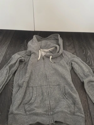 Grå zip-Hoodie - Grå ziphoodie i bra skick Mjuk och bekväm grå hoodie med dragkedja och huva. Klassisk modell som passar till det mesta – perfekt till vardags. Använd men väl omhändertagen, inga större slitningar. Sitter snyggt och är skön att ha på sig året runt.