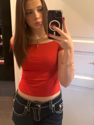 Offshoulder topp i rött och svart - Två stilrena offshoulder toppar i rött och svart. Båda är croppade och har en tight passform som framhäver axlarna. Perfekta att matcha med jeans eller kjol för en trendig look. Gjorda i mjukt bomullsmaterial som är skönt mot huden.