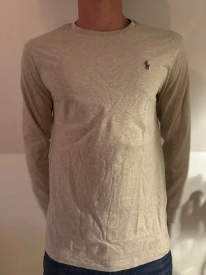 Polo Ralph lauren sweatshirt  - Polo Ralph lauren stickad långärmad, storlek L. Helt ny, taggar/prislapp och kvitto finns. Färg: Beige. Modellen är 186 cm 