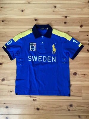Ralph Lauren Sweden polo shirt  - Säljer denna feta Sverige polo tröja från märket Ralphlauren i storlek M. Mycket bra skick då den använts sparsamt. Vid andra frågor är det bara komma dm. 