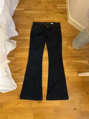 Mörkblå bootcutjeans - Så så snygga jeans! Perfekta färgen och modellen, tyvärr lite små för mig. Midjemått tvärs över är 38cm och innerbenslängden är 87cm. Perfekt för långa personer. De är något slitna på baksidan vid hälen