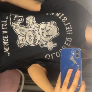 Svart t-shirt med grafiskt nalletryck - svart t-shirt med stort grafiskt tryck av en tecknad nalle och text på framsidan. T-shirten har korta ärmar och en klassisk rund hals. Perfekt för dig som gillar streetwear och unika motiv.den är såååå skön o sova med rekommenderar till den som inte kan sova bra 