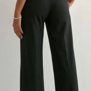 Svarta kostymbyxor med rak passform - Snygga svarta kostymbyxor med rak och lite vidare passform. Byxorna har klassiska fickor fram och bak, bälteshällor och stängs med dragkedja och knapp. Perfekta för en clean och stilren look.