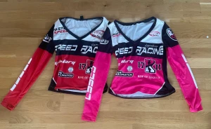 Speed Racing långärmad tröja - Cool långärmad tröja med v-ringning från Speed Racing. Tröjan har ett sportigt tryck med text och racingmotiv i svart, vit, röd och rosa. Materialet är lätt och syntetiskt, perfekt för dig som gillar att sticka ut med färg och grafik. Passformen är normal och designen är inspirerad av motorsport.