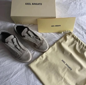Arigato skor zip - Detta är modelen clean 90 zip i grå av axel arigato. Skorna var limited edition och säljs inte längre. Ny pris var 2600. Skorna är i storlek 41.    Priset går att diskuteras!