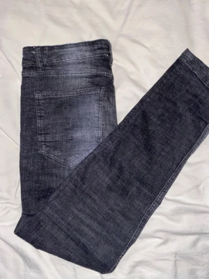 Supply & Demand svarta distressed jeans - Svarta jeans från Supply & Demand med coola slitningar och vita färgstänk på framsidan. Nypris är 650 men säljer för 250. Kan gå ner i pris i snabb försäljning!