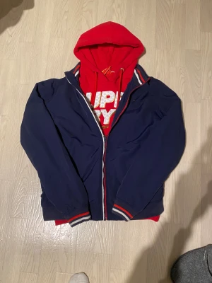 Marinblå vindjacka Hilfiger Denim L-M - Snygg marinblå vindjacka från Hilfiger Denim. Det är storlek L men passar mig som brukar ha storlek M. Skick 8/10. Bara höra av dig vid funderingar😁