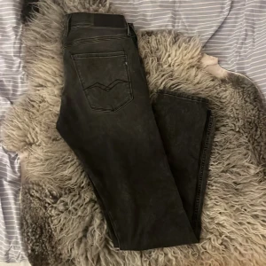 Replay Anbass mörkgråa slim jeans strl 32 - Säljer ett par Replay Anbass jeans i svart/ mörkgrå tvättad färg. Slim fit-modell med klassiska fem fickor, snygga detaljer och Replay-logga på fickan. Jeansen har raka ben och är tillverkade i stretchigt jeanstyg för skön passform. Änvända typ 5 gånger och är inpricip helt nytt skick.