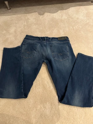 Replay Anbass Hyperflex jeans blå.  W-33 L-32.    7 - Säljer ett par Replay Anbass Hyperflex jeans i klassisk blå färg med snygga slitningar och kontrastsömmar. Modellen har fem fickor, dragkedja och normal passform. Materialet är stretchigt jeans för extra komfort. Perfekt för dig som gillar stilrena och bekväma jeans.