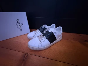 Valentino Garavani Open sneakers - Snygga vita Valentino Garavani Open ganska andvända med snören som är slitna men går lätt och köpa nya snören! och trendiga sneakers. Kommer med originalkartong. Skriv om frågor och pris!