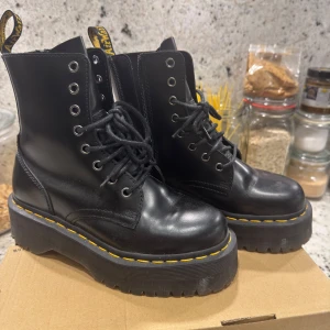 Dr. Martens Jadon Black Boots 37 - Säljer ett par svarta Dr. Martens Jadon boots i storlek 37. De har chunky plattformssula med gul söm, snörning framtill och dragkedja på sidan. Tillverkade i blankt skinn och har en rund tå. I nyskick, endast använda någon timme inomhus 2-3 gånger 