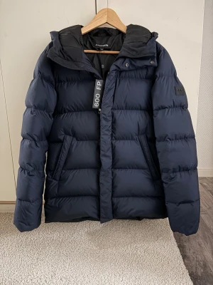 J.Lindeberg - 🔵Jackan är använd ca 5 gånger men har en liten skråma som man ser på bilden, i övrigt så är jackan i fint skick🔵