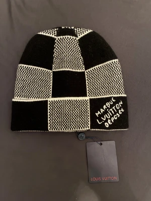 Mössa ifrån L V - Svartvit mössa från L V. Tillverkad i lyxig mix av kashmir, ull och silke. Snygg och unik design som sticker ut, perfekt för dig som gillar exklusiva accessoarer