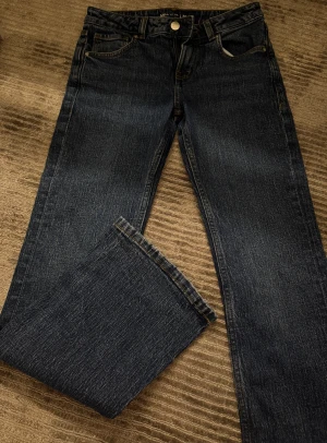 Mörkblå Mira jeans straight fit - Snygga mörkblå jeans från Mira med klassisk femficksdesign och raka ben. Jeansen har kontrastsömmar, bälteshällor och dragkedja med knapp framtill. Materialet är slitstarkt denim och passformen är straight, perfekt för en chill och stilren look.