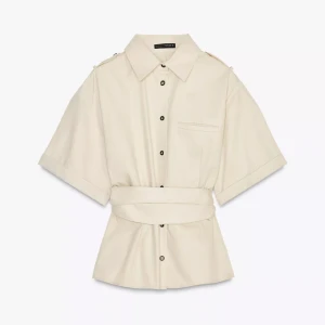 Beige skjorta med bälte och kort ärm - Stilren beige skjorta från Zara med korta ärmar, klassisk krage och svarta knappar framtill. Skjortan har ett brett bälte i midjan som ger en snygg siluett och en liten bröstficka för extra detalj. helt ny och endast testad i strl xs❤️ sitter tajt o formar kroppen så finnttttt🌼