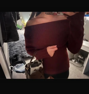 Vinröd offshoulder stickad tröja - Snygg vinröd stickad tröja med offshoulder-design och ribbad struktur. Tröjan har lång ärm och sitter tight, perfekt för dig som vill ha en trendig och bekväm look. Passar dig som gillar att sticka ut med stilrena detaljer.
