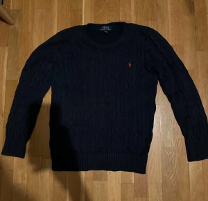 Ralph lauren kabelstickad tröja - En kabelstickad tröja från Polo Ralph Lauren i storlek kids L.                                                     Nypris: 1695kr