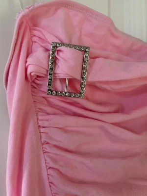 Ljusrosa bandeau tubtopp Y2K - Rosa tub topp med spänne som detalj, inga stenar har lossnat ,endast använd några gånger skitsnygg och as cool!