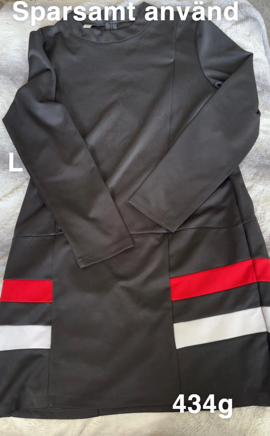 Svart klänning med röda och vita detaljer