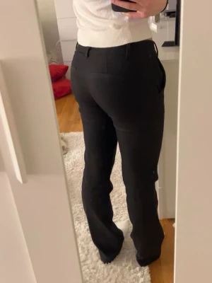 Lowwaist svarta kostymbyxor!! - Snygga svarta kostymbyxor från Bikbok i storlek 34!🥰 passformen är lowwaist bootcut! Andvänt men inga tecken på användning!