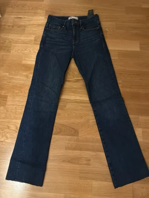 Mörkblå raka jeans från Zara - Snygga mörkblå jeans från Zara med klassisk femficksdesign och raka ben. Jeansen har hög midja och är tillverkade i ett slitstarkt denimtyg med subtila tvättade detaljer. Perfekt för dig som gillar en enkel och stilren look.