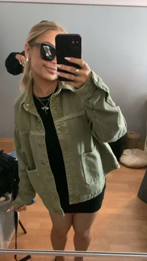 Zara jeansjacka - Säljer en grön zara jacka i jeansmaterial med klassisk krage och stora fickor framtill. Jackan har knappar hela vägen och en loose passform som ger en avslappnad vibe. Perfekt att slänga över en hoodie eller t-shirt för en cool look. köpt för 559 säljer för 400