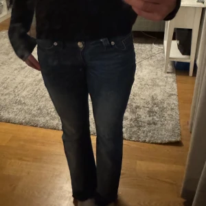 Blå bootcut jeans från Gina Tricot - Snygga blå jeans från Gina Tricot med låg midja och bootcut. Jeansen har dekorativa röda sömmar och broderade bakfickor. Klassisk femficksdesign och tillverkade i jeansmaterial med lätt tvätt. Har sprettat upp de där nere om bågon vill veta. Skriv gärna vid intresse💕